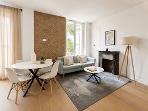 Ein modernes Wohnzimmer mit einem runden Esstisch, einer Couch, einem Kamin und einer Stehlampe.