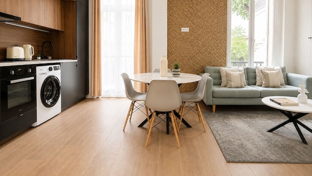 Uma cozinha moderna com eletrodomésticos, uma sala de jantar com mesa e cadeiras, e uma sala de estar com sofá e mesa de centro.