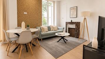 Ein modernes Wohnzimmer mit Essbereich, Kamin und Fernseher.