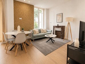 Ein modernes Wohnzimmer mit Essbereich, Kamin und Fernseher.