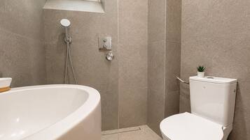 Ein Badezimmer mit Badewanne, Toilette und Dusche.