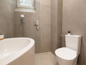 A bathroom with a bathtub, toilet, and shower. - Elegant Appartement 2 pieces au 5e  (Paris)
