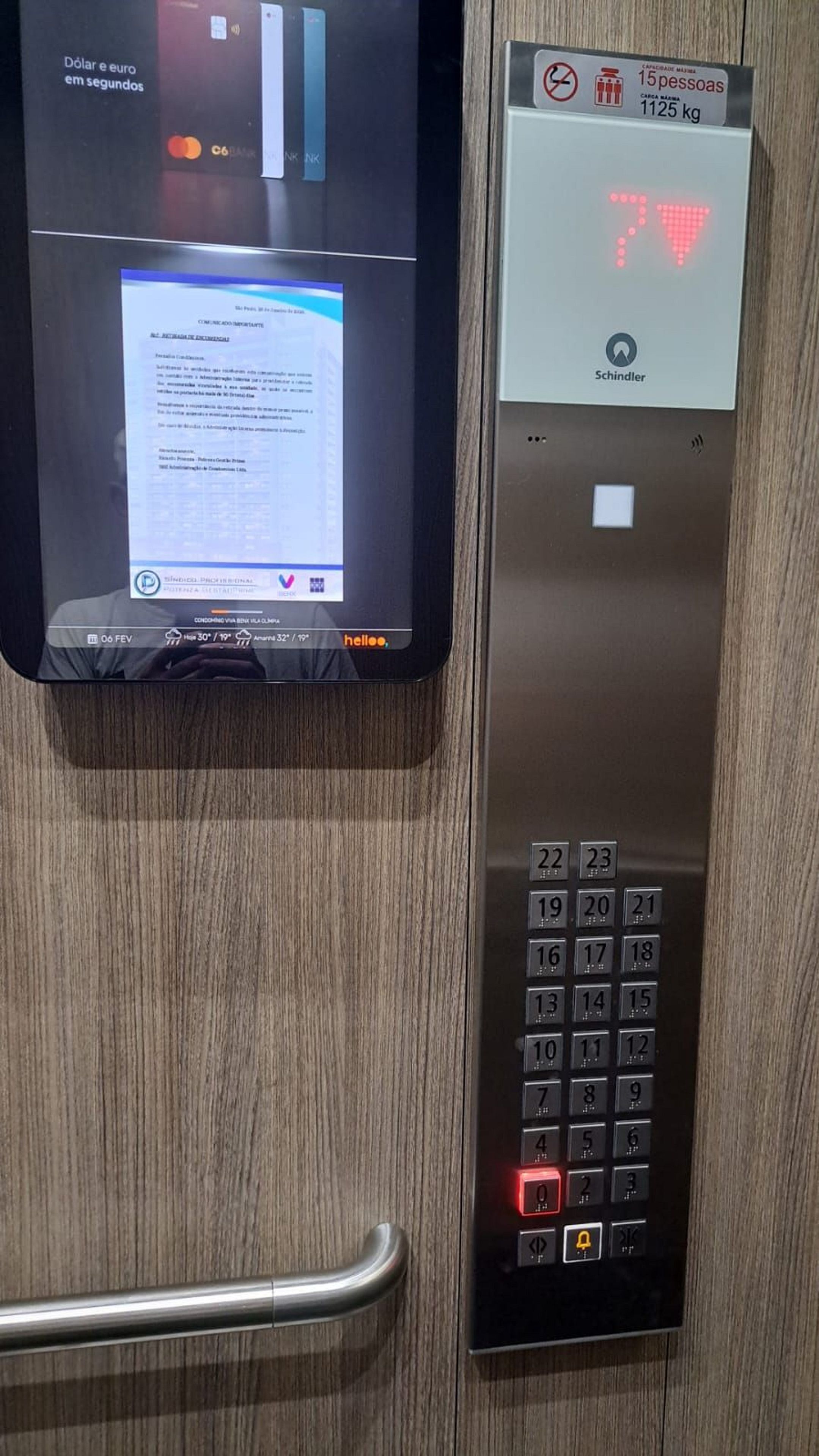 An elevator with a digital display, a keypad, and a Schindler brand sign.