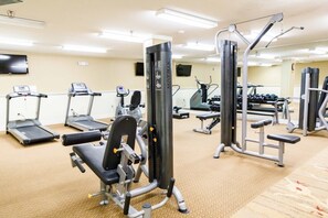 Ein Fitnessstudio mit Laufbändern, Kraftgeräten und Kurzhanteln.