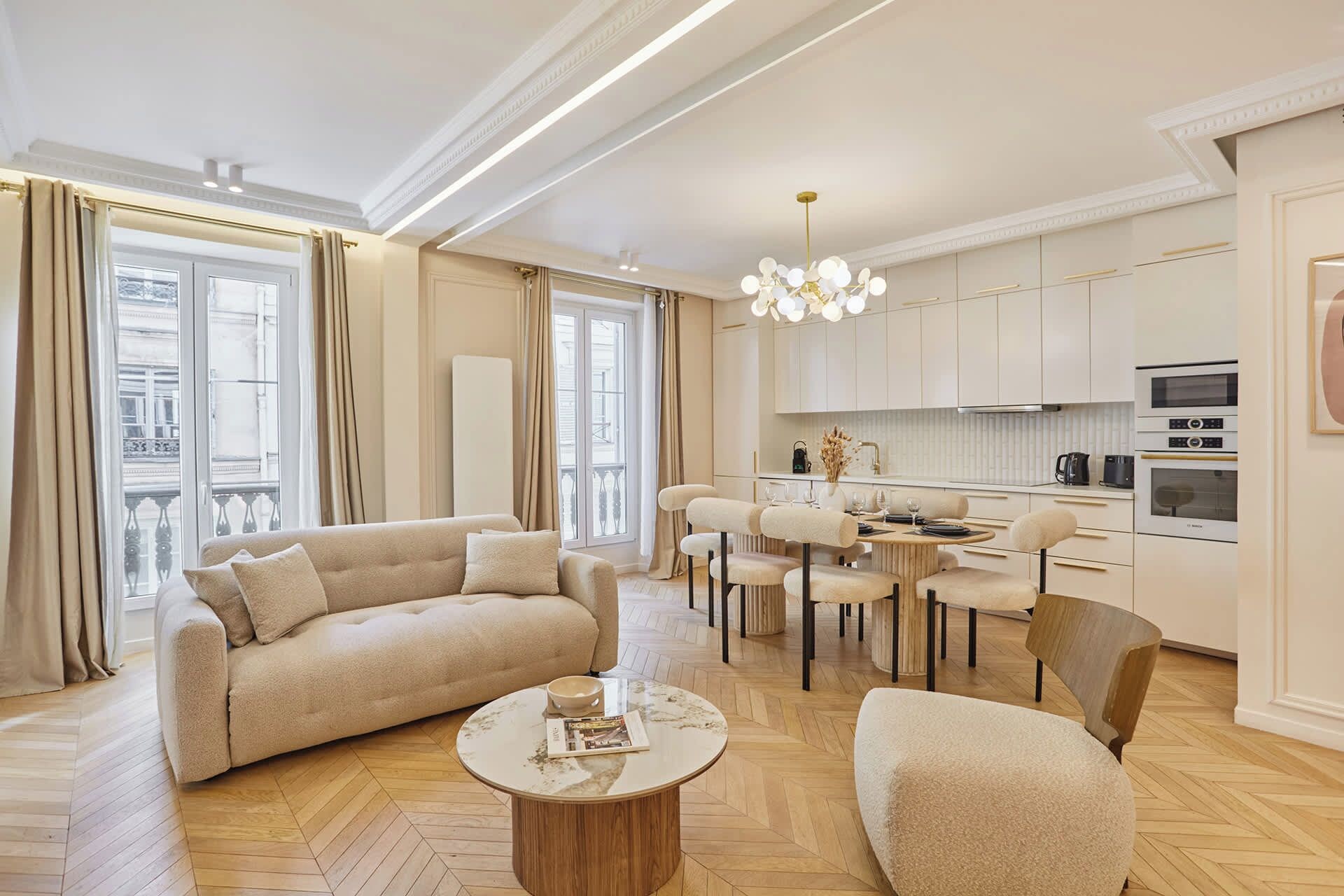 A modern living room with a sofa, coffee table, and dining area with chairs.