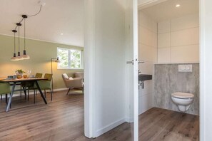 Un intérieur moderne comprenant un coin repas, une cuisine et une salle de bain.