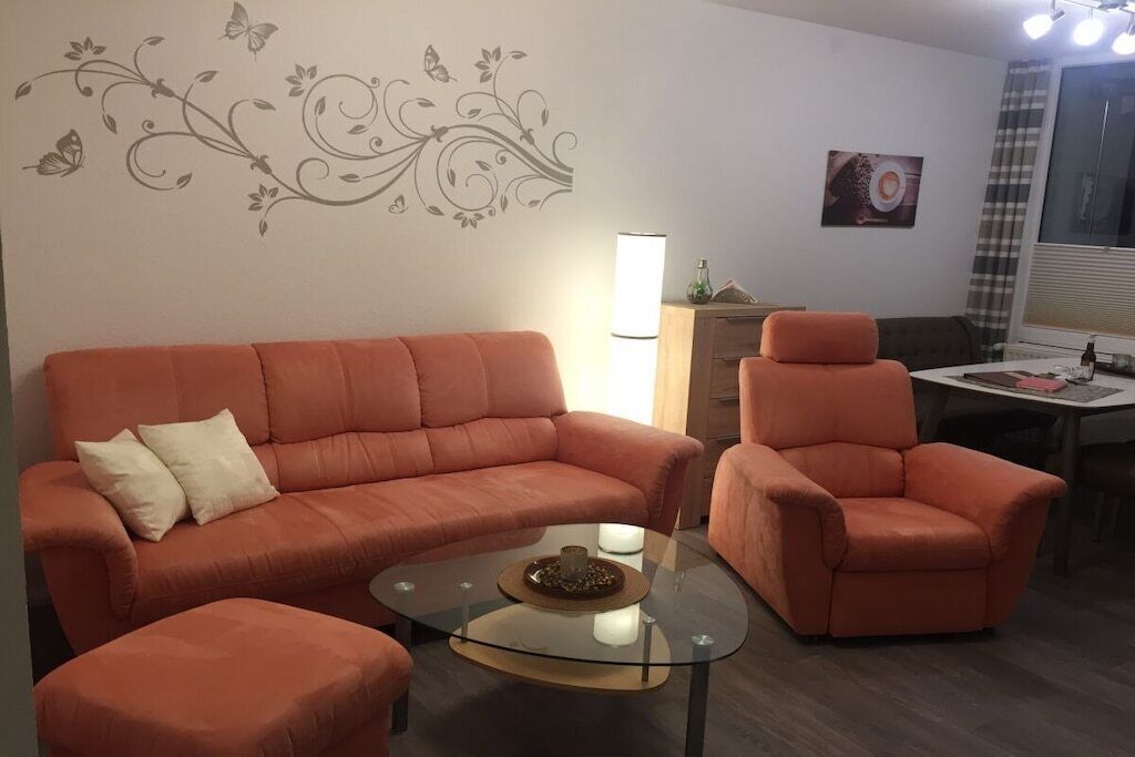 Un salon avec un canapé, un fauteuil et une table basse.