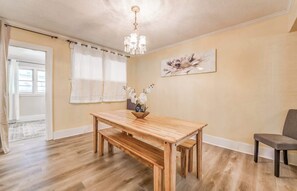 A dining area with a wooden table, bench, and a chandelier. - Near Shopping & Dining- Magic in Midtown- Unit A (Memphis)