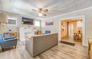 A modern living room with a fireplace, a ceiling fan, and a dining area. - Near Shopping & Dining- Magic in Midtown- 2 Units (Memphis)