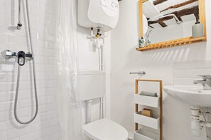 A modern bathroom with a toilet, shower, and sink. - Chic Studio for 4 Le Marais Charm (Paris)