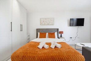 Ein Hotelzimmer mit einem Bett, einem Fernseher und einem Schreibtisch.