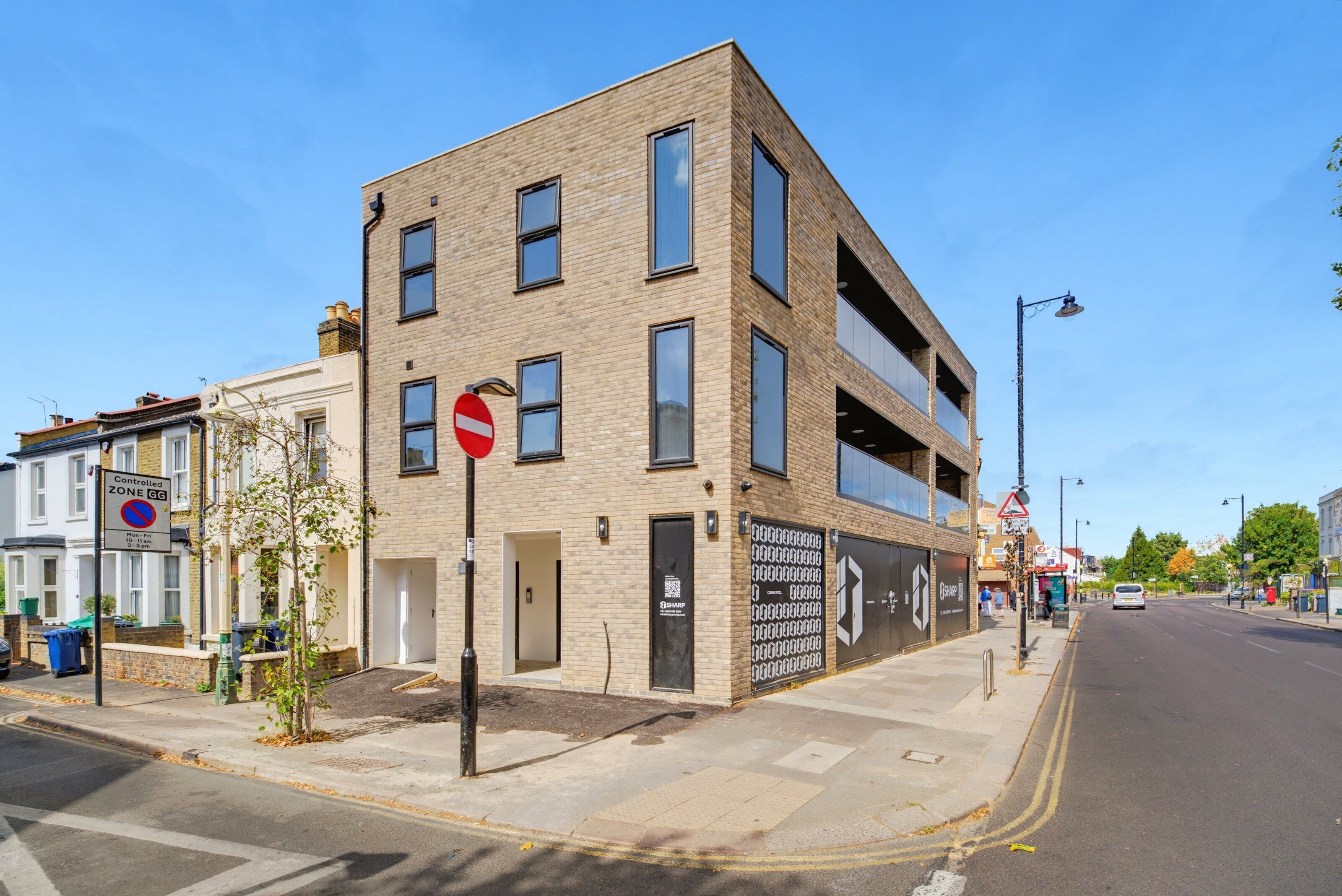 A multi-story building with a no entry sign, a QR code, and a controlled zone sign.