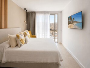 A hotel room with a large bed, a view of the beach, and a painting on the wall. - Kaiman 19 by VillaGranCanaria (San Bartolomé de Tirajana)