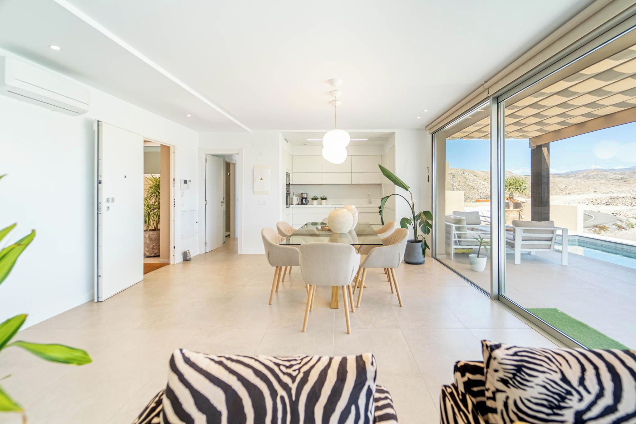 Ein modernes Interieur mit Essbereich, Küche und Blick ins Freie.