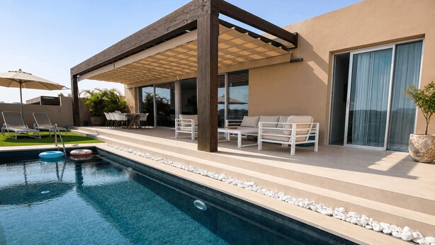 Un área de piscina exterior moderna con pérgola, sillas de descanso y un comedor.