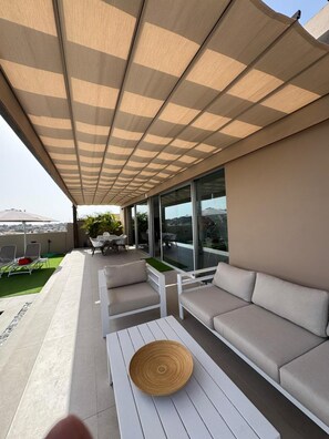 An outdoor seating area with a canopy, a sofa, a table, and a view of the city. - Kaiman 19 by VillaGranCanaria (San Bartolomé de Tirajana)