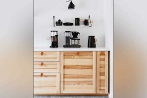 A kitchenette with a coffee maker, a kettle, and a shelf with kitchenware. - Holnis Customs House (Glücksburg)