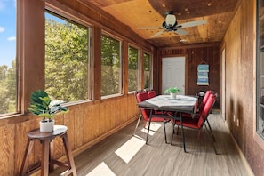 A wooden-paneled room with a table and chairs, large windows, and a ceiling fan. - Big Cabin close to Silver Dollar City with 2 Living Areas, 150 acres, Private Lake/34 (Branson West)
