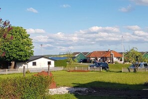 A residential area with houses, a flag, and a grassy field. - Herring in the Fisherman's House (Hohwacht)