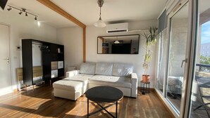 A modern living room with a sectional sofa, a small table, and a potted plant.
