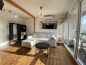 A modern living room with a sectional sofa, a small table, and a potted plant.
