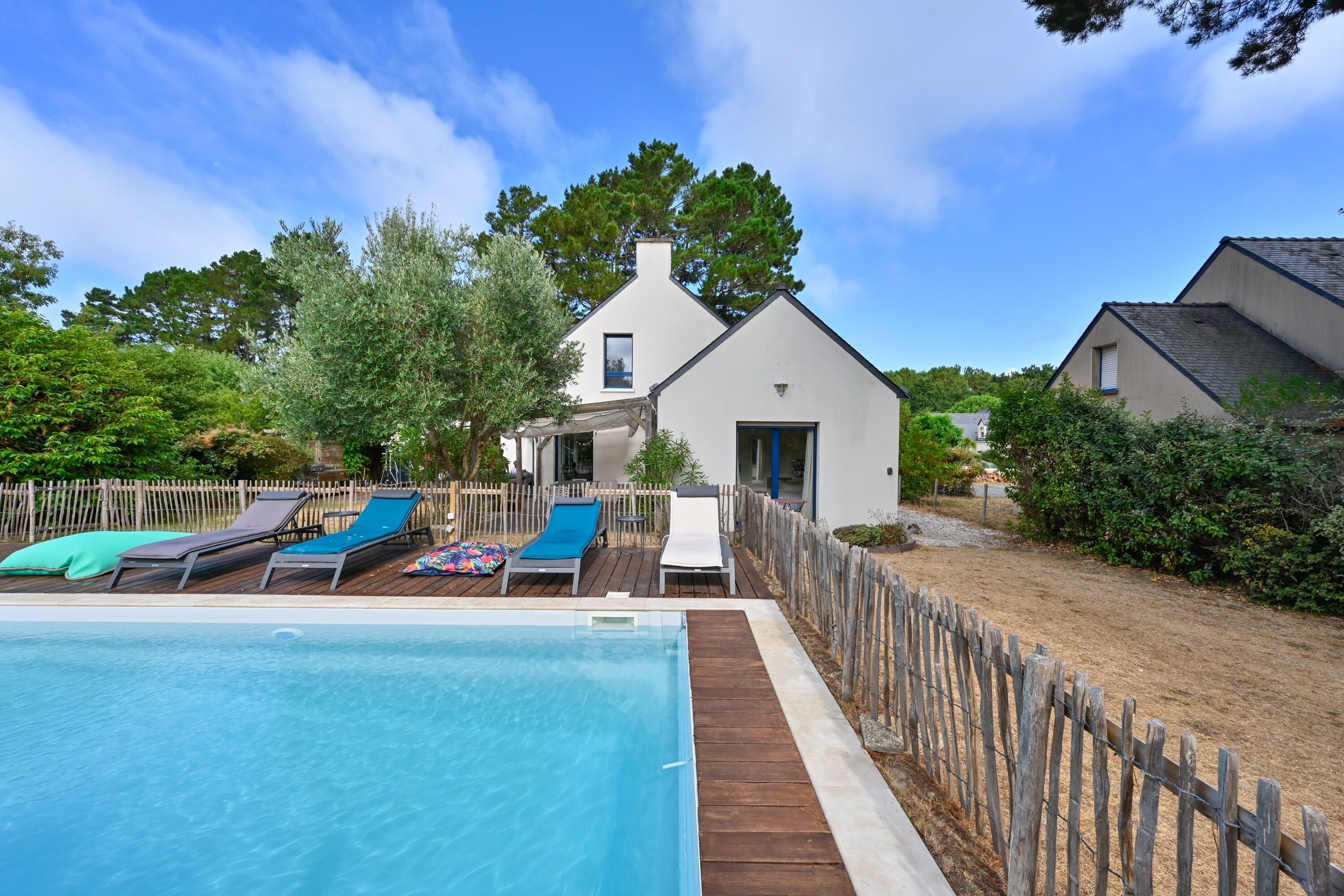A pool area with lounge chairs and a wooden deck.