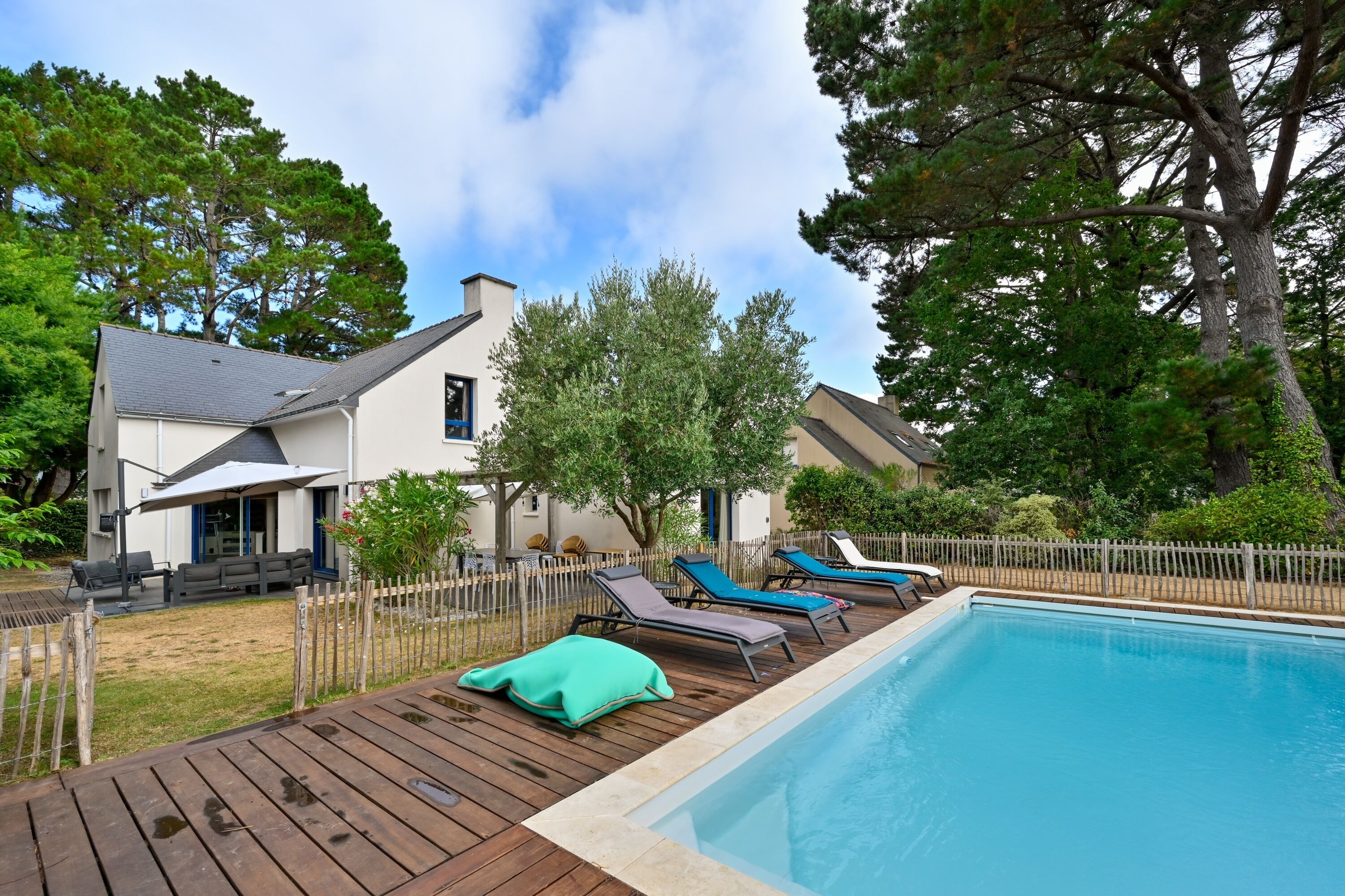 A swimming pool with lounge chairs and a wooden deck.