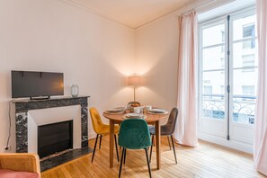 En matplats med en öppen spis, en tv och ett bord dukat för frukost.