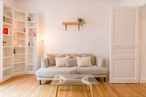Ein Wohnzimmer mit einer Couch, einem Couchtisch und einem Bücherregal.