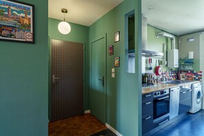 A kitchen with a washing machine, a stove, and a sink. - L’Écrin de Limoges - Grand studio avec parking (Limoges)