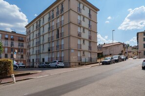 A multi-story residential building with balconies, parked cars, and a clear sky. - L’Écrin de Limoges - Grand studio avec parking (Limoges)