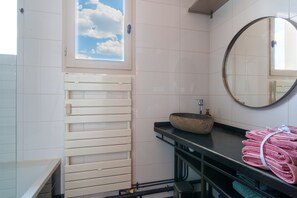 A bathroom with a window, a sink, a mirror, and towels. - L’Écrin de Limoges - Grand studio avec parking (Limoges)