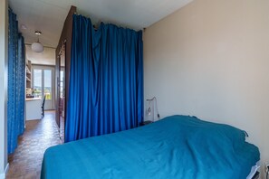A bedroom with a bed, a window, and a view of the outside. - L’Écrin de Limoges - Grand studio avec parking (Limoges)