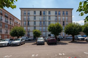 A multi-story residential building with a parking lot in front. - L’Écrin de Limoges - Grand studio avec parking (Limoges)