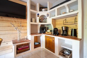 A compact kitchen with wooden shelves, a coffee maker, and a decorative vase. - Le Charme de Villefort - Maison pour 6 (Villefort)