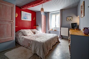 Una camera da letto con un letto, una cassettiera, una televisione e una finestra.