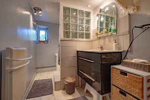 Un bagno con vasca, lavandino, specchio e finestra.