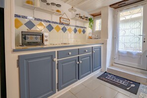 A kitchen with a microwave, cabinets, and a sign that says 'Family is forever.'