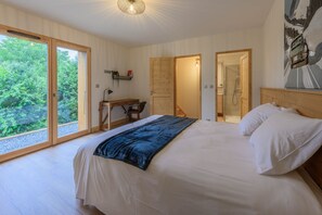 A bedroom with a large bed, a desk, and a shower area. - Chalet Adenore - Triplex proche des pistes (Samoëns)