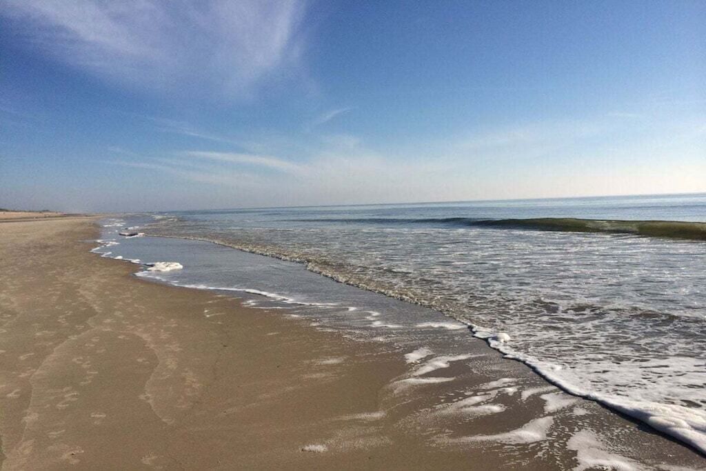 A beach with a sandy shore and gentle waves.