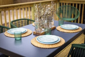 A table set with plates, glasses, and a decorative vase. - Bright Art-Filled Home · Walk to Ocean View Beach (Norfolk)