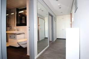 Un baño moderno con inodoro, lavabo y espejo.