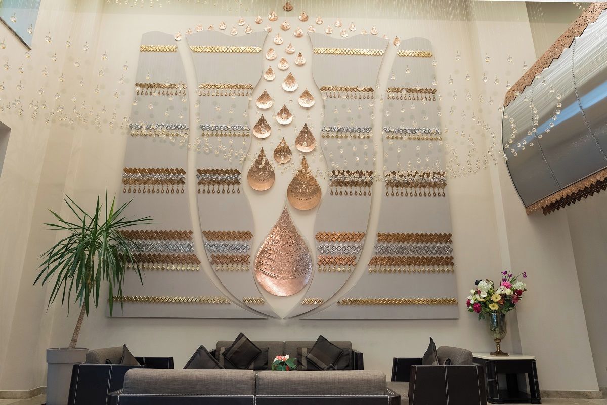 Un interior moderno con una obra de arte decorativa, un sofá y una planta en maceta.