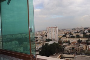 A cityscape with a prominent high-rise building in the center, surrounded by various other buildings. - NEWDAY (HUSSEIN DEY)