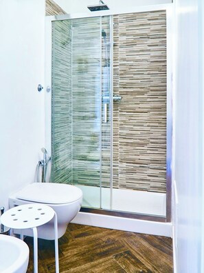 A modern bathroom with a glass-enclosed shower, a toilet, and a sink. - Spending the Winter in Sicily – Stay in a Central Location, Just 200 m from the Sea (Capo d'Orlando)