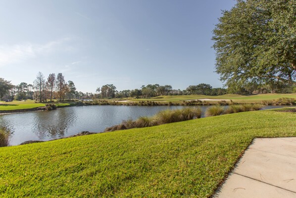 A golf course with a pond, grassy areas, and trees. - St. Augustine | Old Town Retreat | Pool & Historic Charm (St. Augustine)