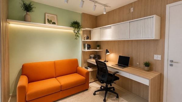 Un espacio de oficina moderno con sofá, escritorio, silla y estanterías.