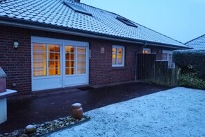 Een woonhuis met een bakstenen gevel, een pannendak en een garage.