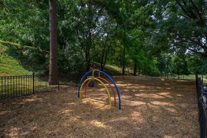 Ein Park mit einem Spielplatz und einer bunten Bogenkonstruktion.