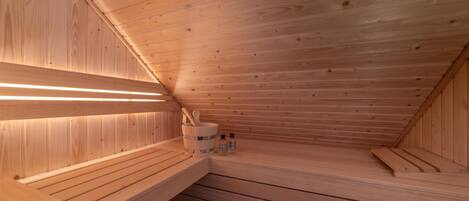A wooden sauna with benches and a wooden wall.